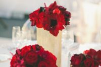 22 hot red blooms in gold vases with black ribbon for a chic wedding table setting