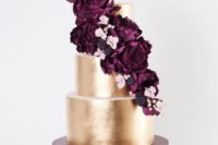 23 a metallic gold wedding cake topped with plum blooms, blackberries and pink flowers