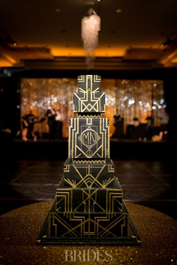 A square multi layer black and gold wedding cake with geometric decor