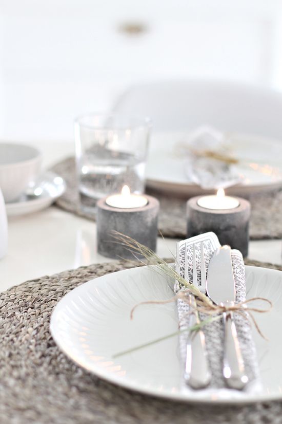 Concrete candle holders for a minimalist tablescape and wicker chargers for a texture