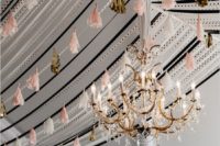 handmade tassel garlands over the reception and a large glam chandelier that fits the look