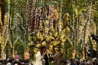 23 unique elf-inspired ceremony space with giant trees, lots of greenery, flowers and moss, the aisle covered with petals completely