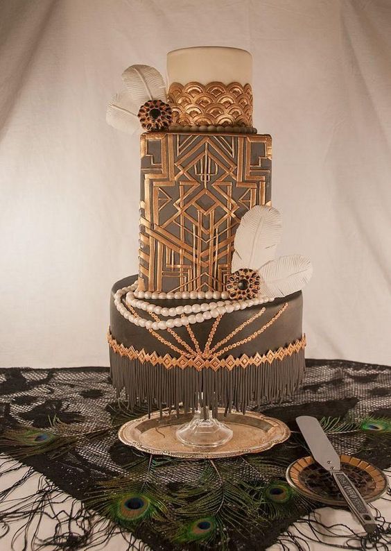 a black and copper wedding cake with geo decor, scallops and feathers