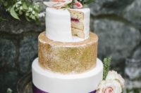 27 a wedding cake with a white layer, a gold glitter layer and a white layer with a purple ribbon