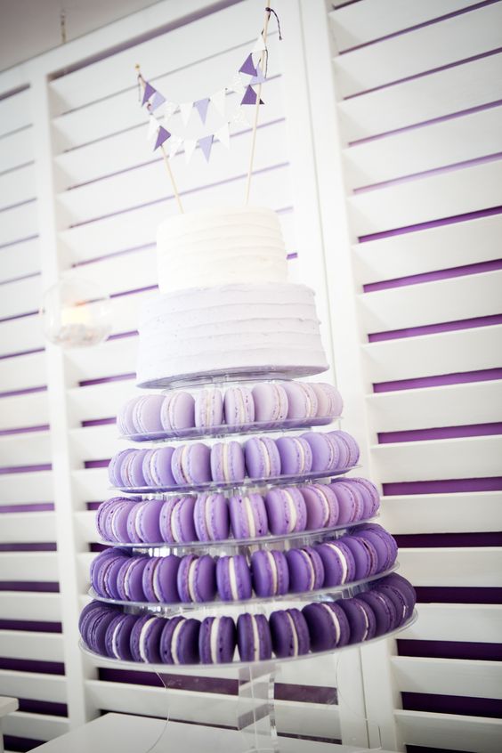 purple ombre macaron tower with a white two-tier wedding cake