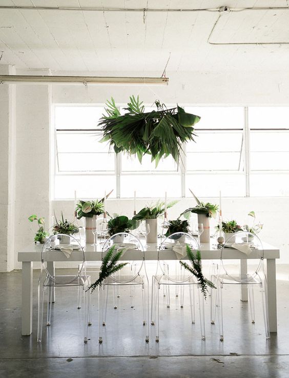 a concrete table, acrylic chairs ad lush greenery for a minimalist wedding