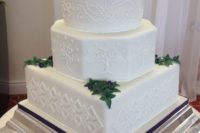 28 cream wedding cake with rings on top, edible greenery and leaves and textural images