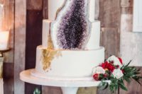 29 a white wedding cake with gold leaf decor and an amethyst geode part