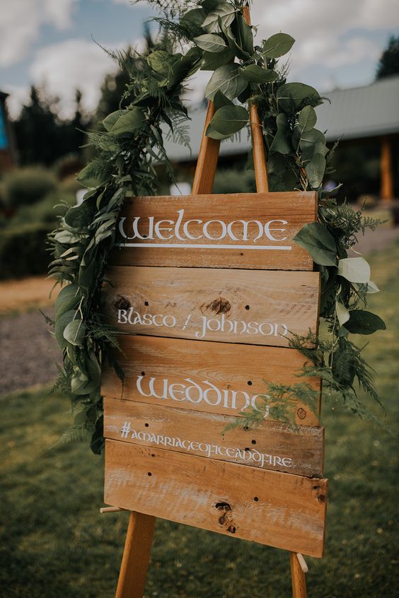 a LOTR-styled sign with a greenery garland over it is a cool idea for a fantasy wedding and you can make it yourself