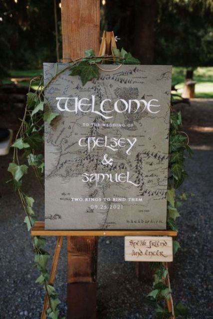 a LOTR wedding sign with vines on top and a sign is a cool idea for wedding with fantasy themes