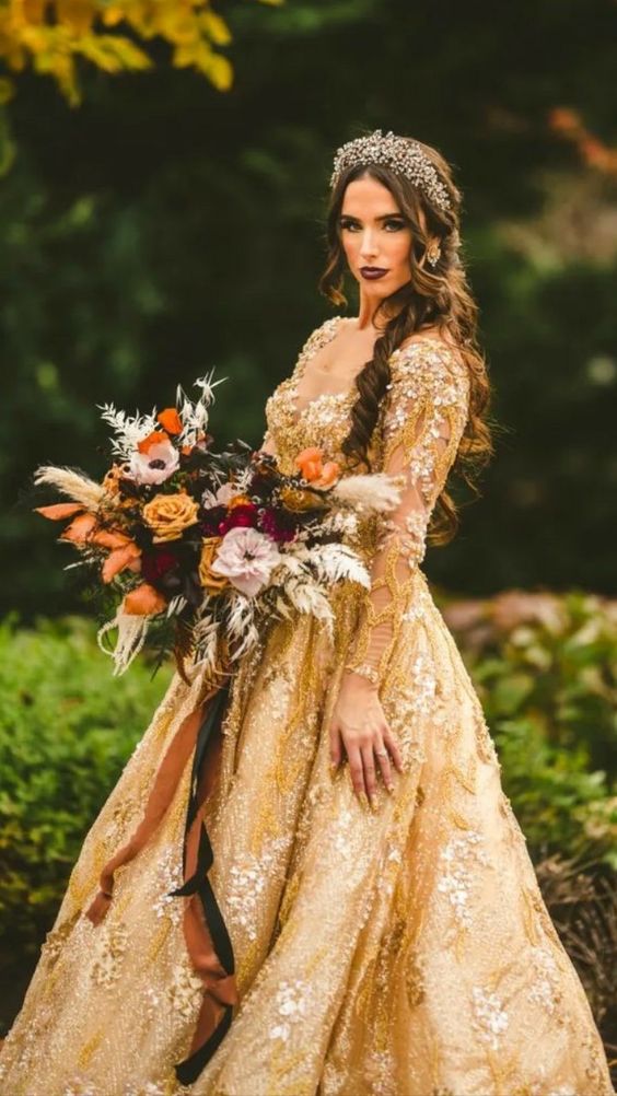 a beautiful and refined bridal look with a gold lace applique wedding ballgown, a headpiece and earrings and a bold bouquet
