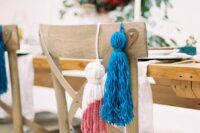 a blue and a colorful block pink tassel are a nice way to style your wedding chairs, they will add color and interest to it