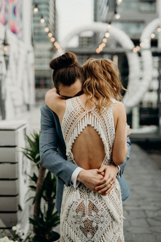 a boho macrame-inspired lace wedding dress decorated with tassles on the back is a gorgeous idea for a boho bride