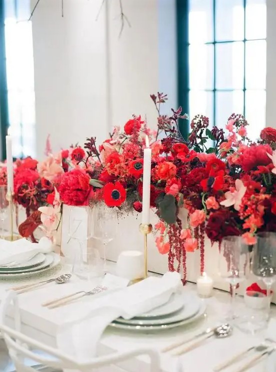 a bold red floral centerpiece - a box with bright blooms and leaves and some neutral candles for a chic look