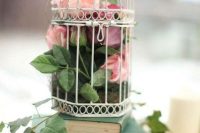 a book stack with a cage, moss, blooms and greenery is a lovely book lover wedding idea
