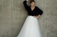a catchy and contrasting bridal look with a black cropped cardigan and a tulle layered skirt with a train