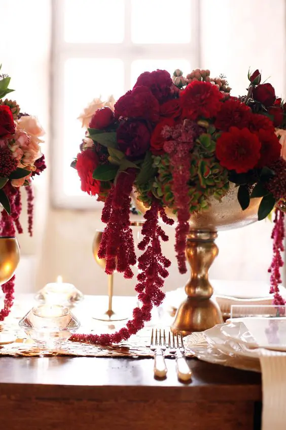 a fantastic wedding centerpiece of a gold bowl with lush red blooms and greenery and amaranthus is amazing