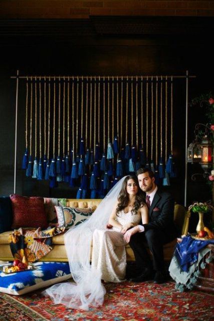 a gorgeous and bold light and electric blue tassels on rop are an amazing and bright wedding backdrop with a touch of boho