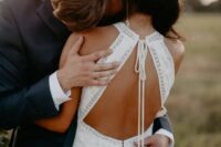 a gorgeous modern boho fitting wedding dress with lace appliques, a halter neckline, a keyhole back on ties is a lovely idea