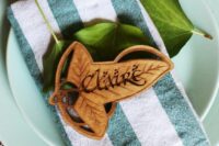 a hobbit place setting with green plates, a striped napkin and a wooden leaf buckle just like in LOTR