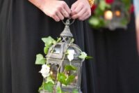 a lantern with vine and garden roses instead of a usual bouquet is a cool solution for a LOTR wedding