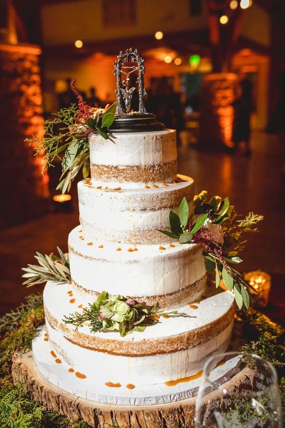 a naked wedding cake decorated with greenery and a cake topper is a cool idea for your fantasy wedding