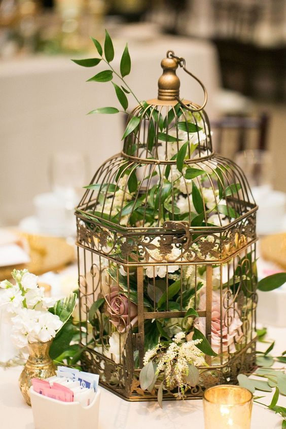 a refined brass birdcage with blooms and greenery is a chic idea for an inspiring and sophisticated wedding table