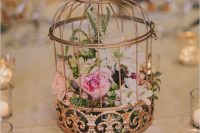 a refined copper cage with white and pink blooms and greenery is a beautiful wedding centerpiece