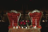a refined vintage space with a gold sequin tablecloth, a red floral centerpiece and refined red chairs is wow