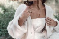 a strapless printed wedding dress paired with a soft plush cardigan with long sleeves for an out of the box bridal look