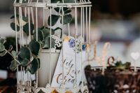 a white cage with a potted plant and a card is a cool and very budget-friendly decor idea
