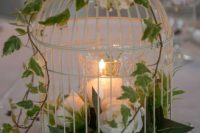 an exquisite white cage with white blooms and a candle plus some baby’s breath on top is amazing