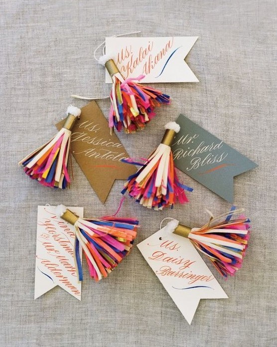 colorful tassels as wedding escort cards are amazing for any wedding, they look bold and cool and can match a boho wedding