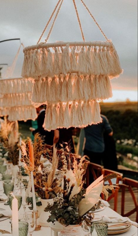 gorgeous neutral tassel chandeliers will be a perfect accent for a boho wedding, whether they are with lights or just decor