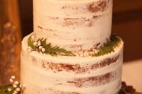 02 a simple semi naked wedding cake topped with pinecones, ferns and berries for a rustic winter wedding