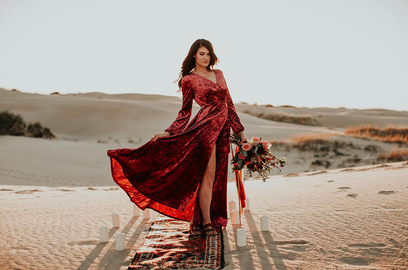 She also had a wrap red crushed velvet dress on, and it looked just jaw-dropping in the backdrop of white dunes