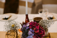 06 A pretty wedding centerpiece of a wood slice, some bold blooms, a pinecones and candles