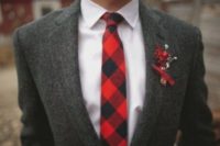 08 a groom wearing a grey tweed suit and a plaid tie with a red boutonniere