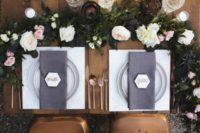 09 The sweetheart table was decorated with a lush bloom and greenery garland, geo cards, copper cutlery and grey napkins