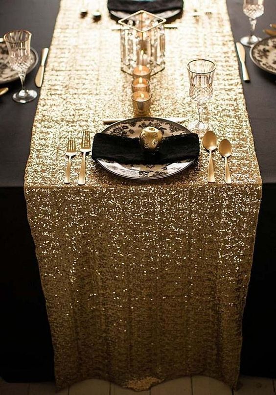 a gold sequin table runner for a black and gold wedding tablescape