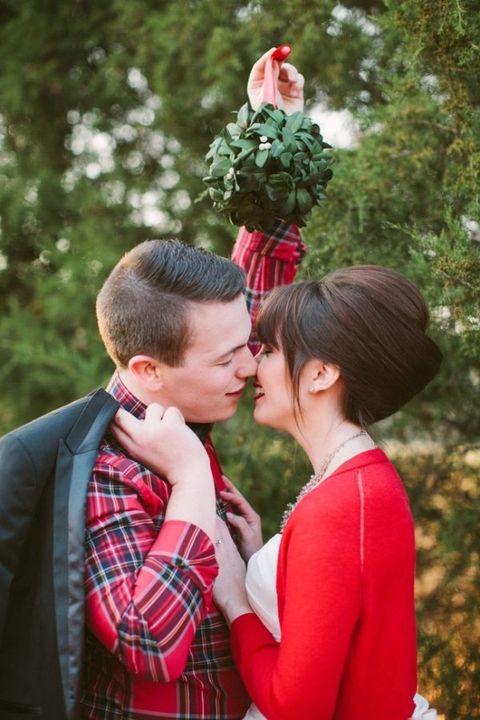 the groom wearing a red plaid shirt and the bride in a matching red cardigan