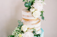 10 The naked wedding cake had a blue layer and neutral blooms and greenery to match the shoot