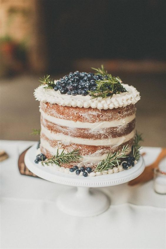 a yummy spiced naked wedding cake with frosting and berries