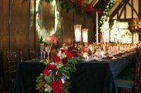13 a cascading holiday-inspired table runner with magnolia leaves, evergreens, red roses and pinecones for a festive wedding
