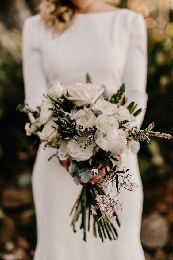 a modern bouquet with white roses, evergreens and foliage for a textural look