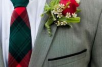14 the groom in a grey suit with a traditional christmas-inspired tie and a red boutonniere