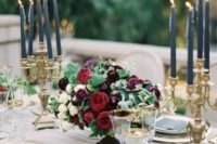 15 a luxurious table setting with gold candle holders, chargers, gold rim glasses and dark florals