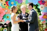 15 various colorful paper flowers on the wedding arch create a bold and cheerful ambience