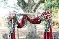 16 a luxurious winter ceremony arch with marsala velvet, lush roses and ucalyptus
