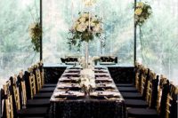 17 a jaw-dropping table setting with gold sequin tablecloth, gold cutlery and candle holders and black and gold chairs